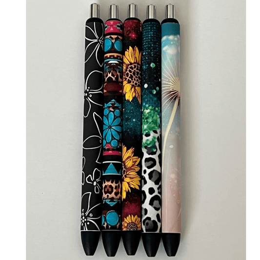 Photo of 5 pens- black and white flowers, turquoise western, sunflower galaxy, multicolor leopard print, and dandelion.